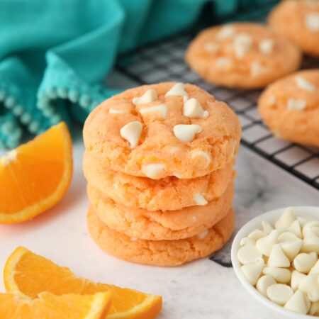 Stack of orange creamsicle cookies made with cake mix, jello, and white chocolate chips.