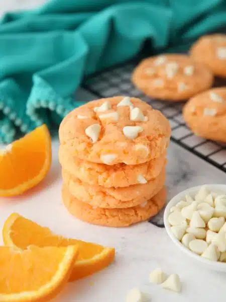 Stack of orange creamsicle cookies made with cake mix, jello, and white chocolate chips.