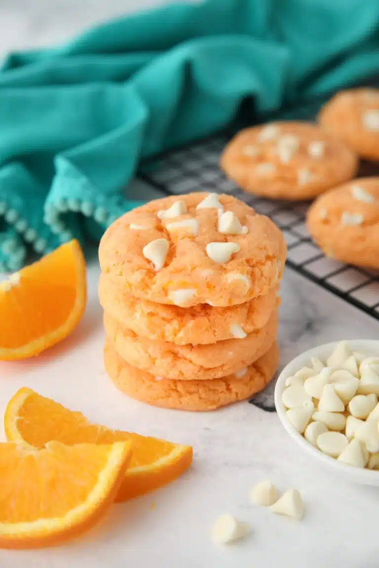 Stack of orange creamsicle cookies made with cake mix, jello, and white chocolate chips.