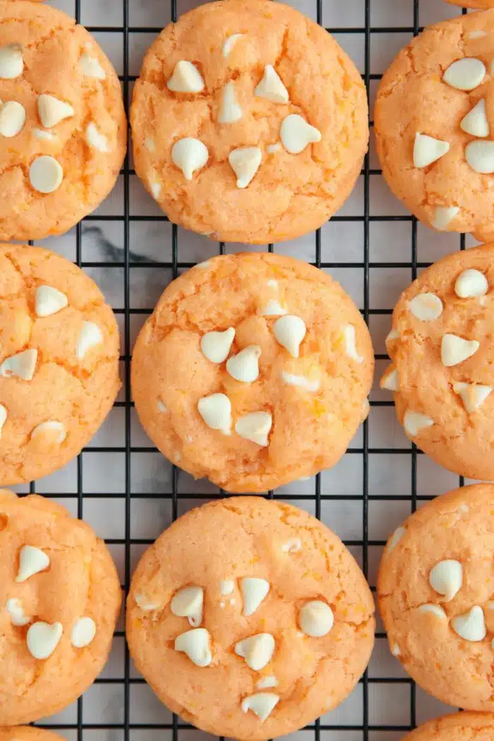 Orange creamsicle cookies cooling on a wire rack.