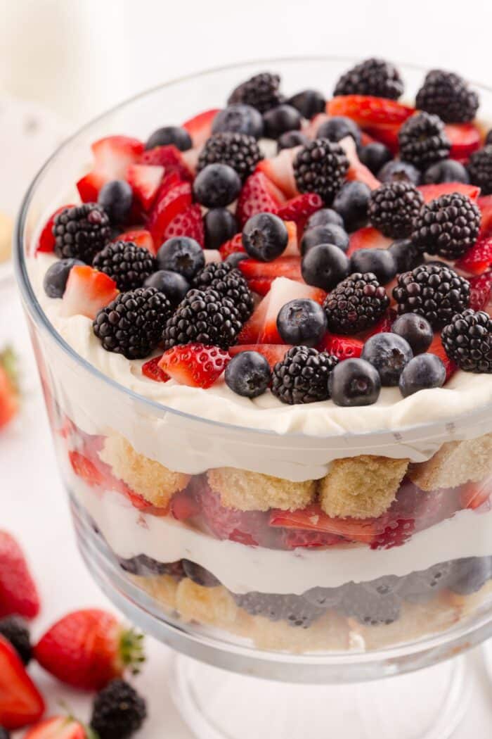 Close up of 4th of July trifle in a clear trifle bowl showing layers of pound cake, whipped cream cheese, and berries.