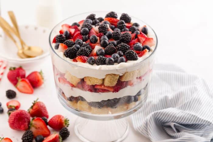 Close up of 4th of July trifle in a clear trifle bowl showing layers of pound cake, whipped cream cheese, and berries.