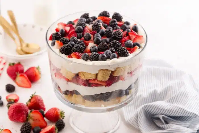 Close up of 4th of July trifle in a clear trifle bowl showing layers of pound cake, whipped cream cheese, and berries.