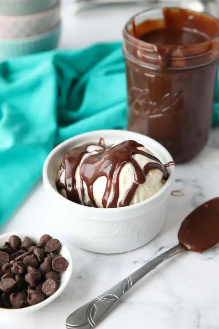 Hot fudge on top of a bowl of ice cream.