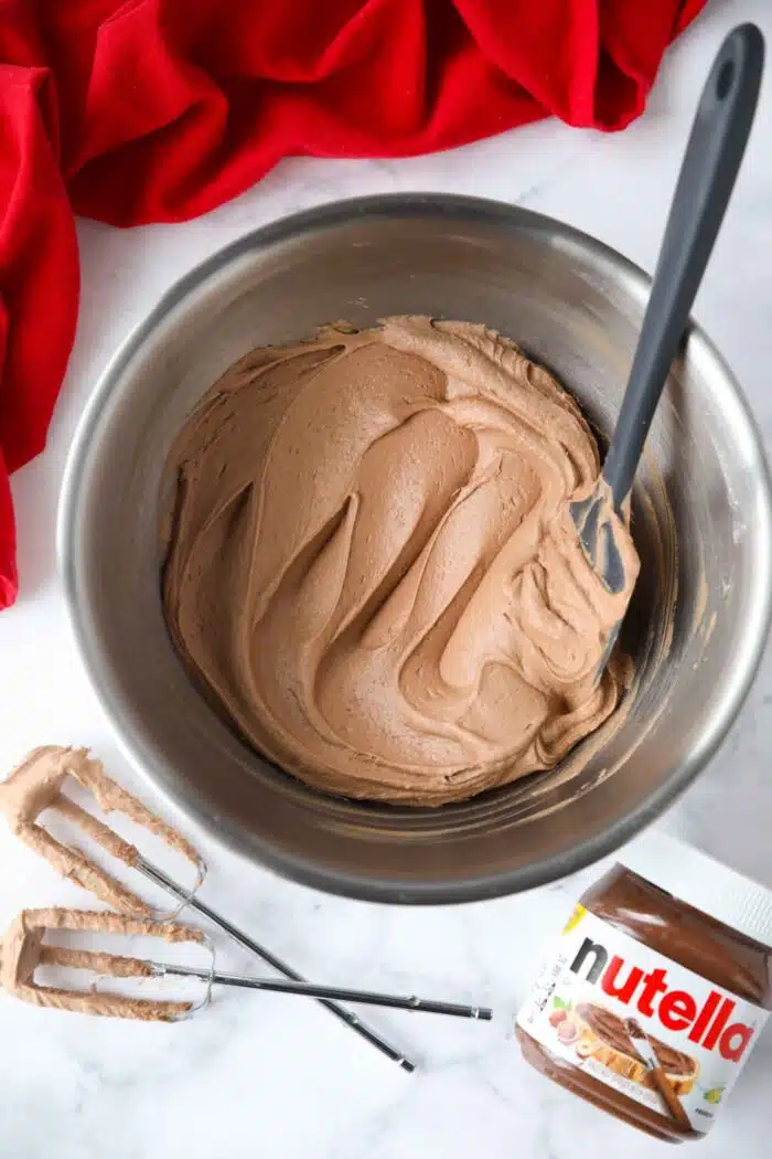 Bowl full of Nutella frosting swirled with a spatula.