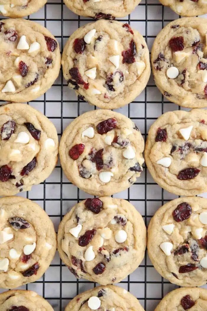 Close up of cranberry white chocolate cookies on a wire cooling rack.