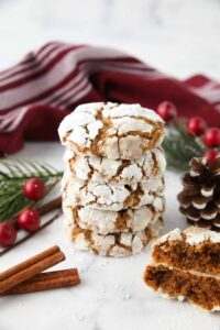 Stack of gingerbread crinkle cookies with powdered sugar cracks.