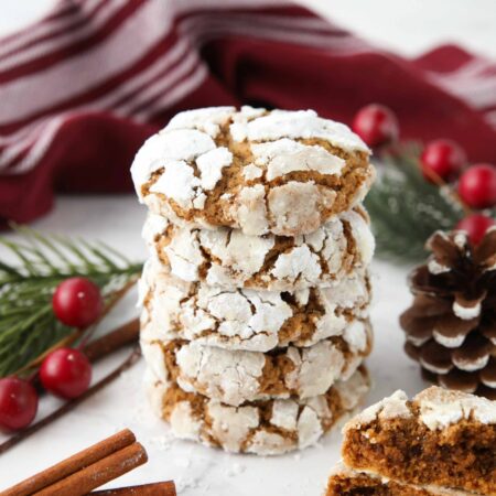 Stack of gingerbread crinkle cookies with powdered sugar cracks.