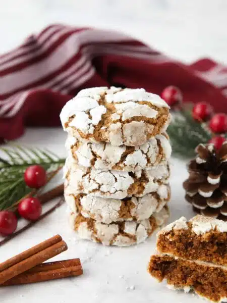 Stack of gingerbread crinkle cookies with powdered sugar cracks.