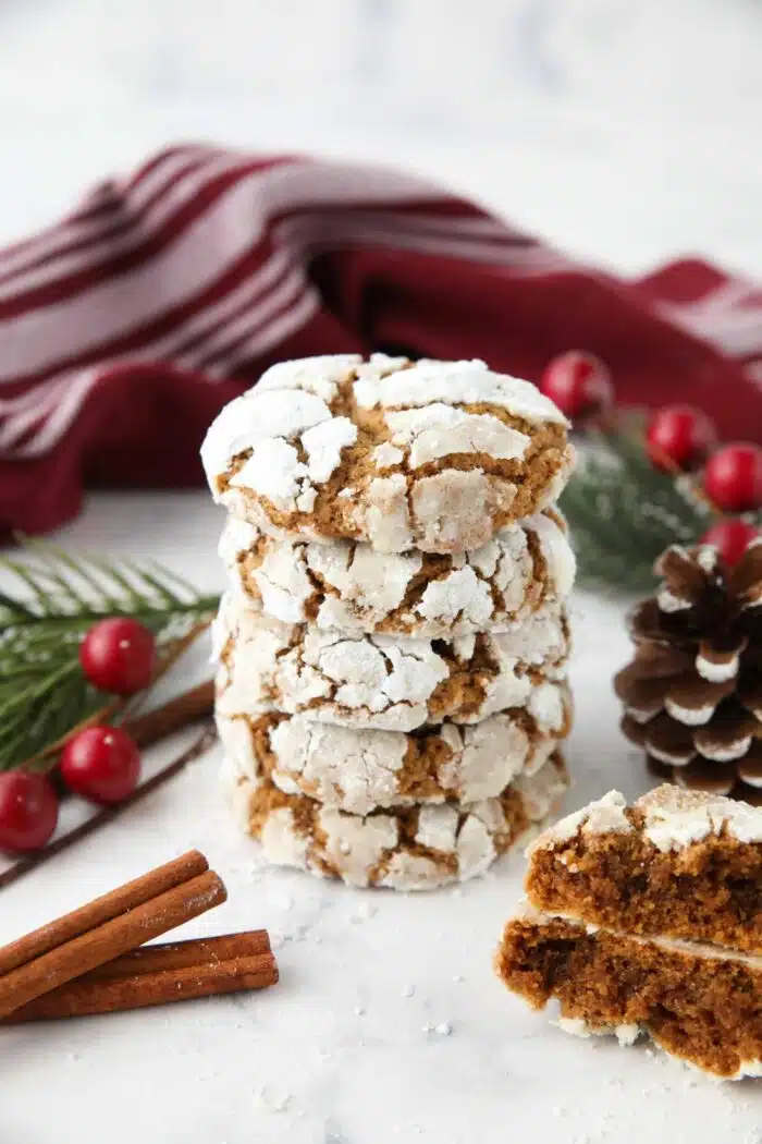 Stack of gingerbread crinkle cookies with powdered sugar cracks.