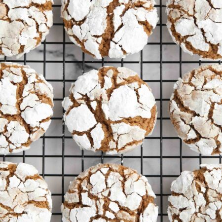 Gingerbread Christmas crinkle cookies on a wire cooling rack.