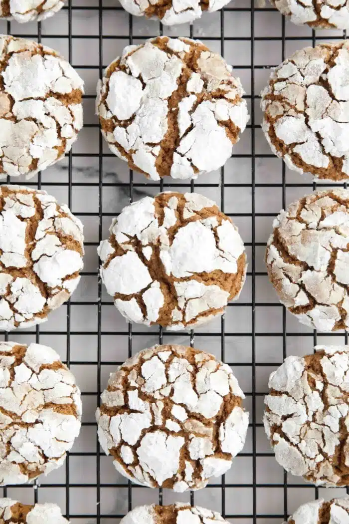 Gingerbread Christmas crinkle cookies on a wire cooling rack.