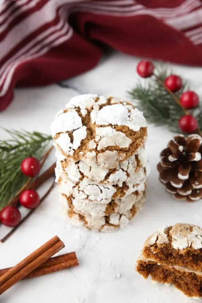 Stack of gingerbread Christmas crinkle cookies with powdered sugar cracks.