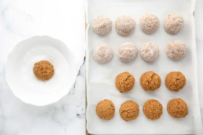 Coating gingerbread cookie dough with granulated sugar.