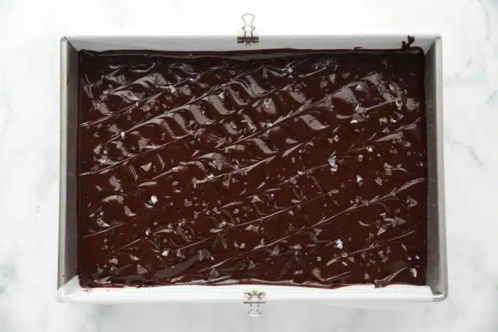 Ganache spread in pan an topped with flaky salt.