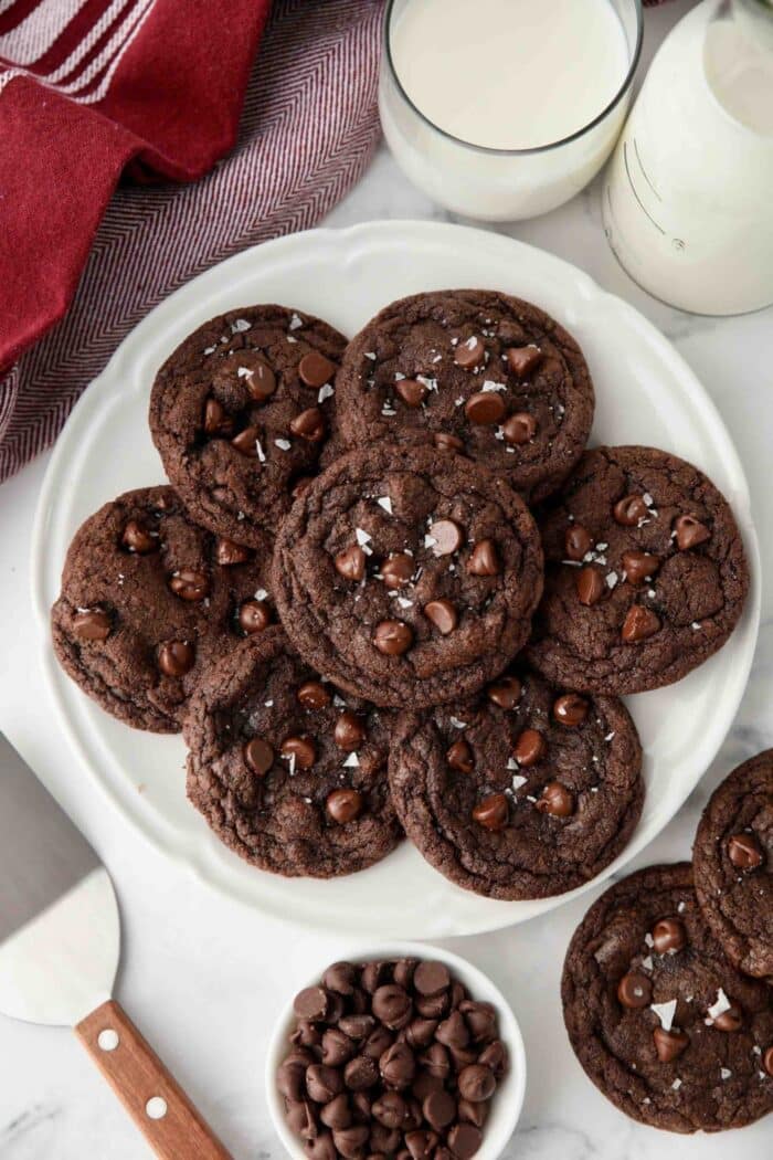 Plate of double chocolate chip cookies with flaky sea salt sprinkled on top.