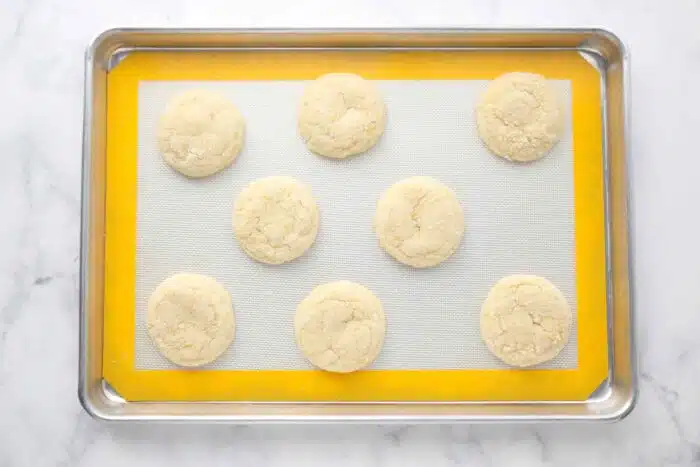 Baked lemon cookies on a baking sheet tray.