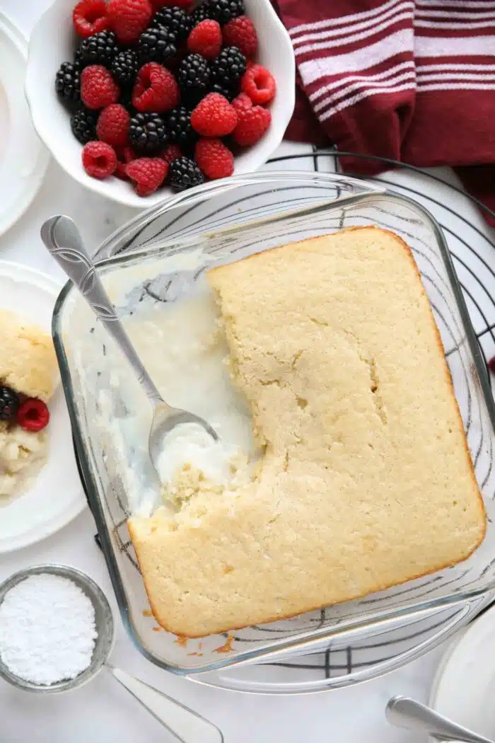 Top view of vanilla pudding cake in a baking pan with vanilla cake on top and vanilla pudding on bottom.