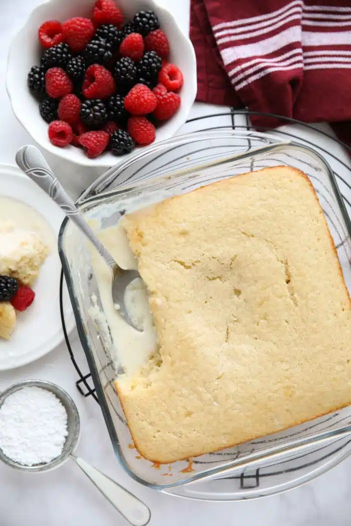 Top view of vanilla pudding cake in a baking pan with vanilla cake on top and vanilla pudding on bottom.