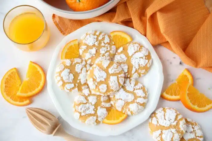 Orange cookies on a plate with orange slices.