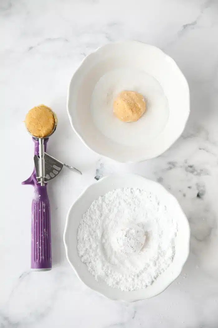 Double coating orange cookie dough with sugar and powdered sugar.