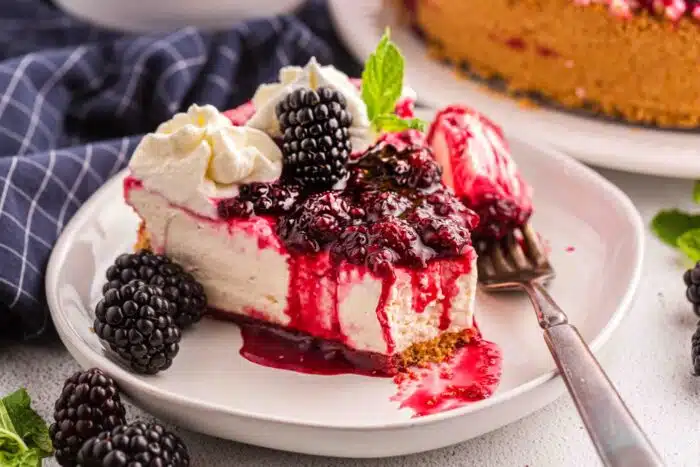 Forkful removed from a slice of no bake blackberry cheesecake.