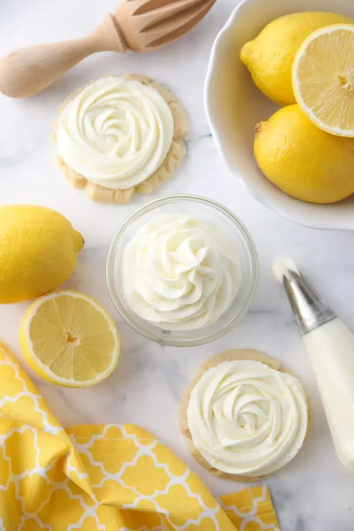 Lemon frosting piped into a small bowl and on top of sugar cookies.