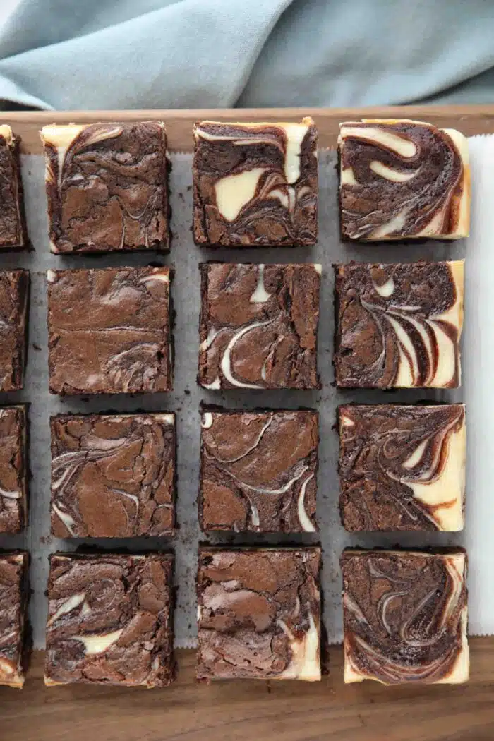 Cutting board with cream cheese brownies.