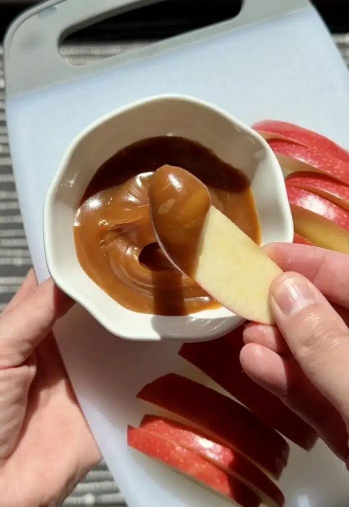 Slice of apple with salted caramel dip.