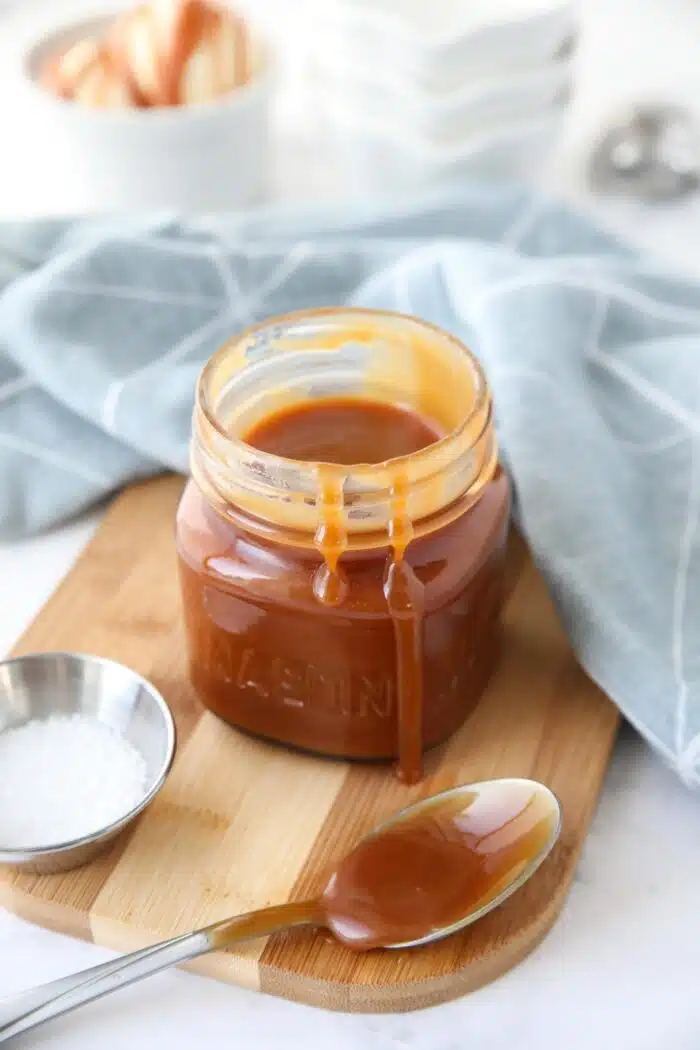 A jar of salted caramel sauce with drips down the side.